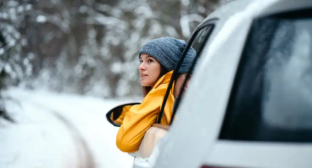 Fahrerin schaut aus einem Auto, das im Schnee fest steckt